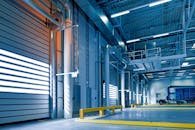 Spacious and modern warehouse interior with parked truck and steel structures.